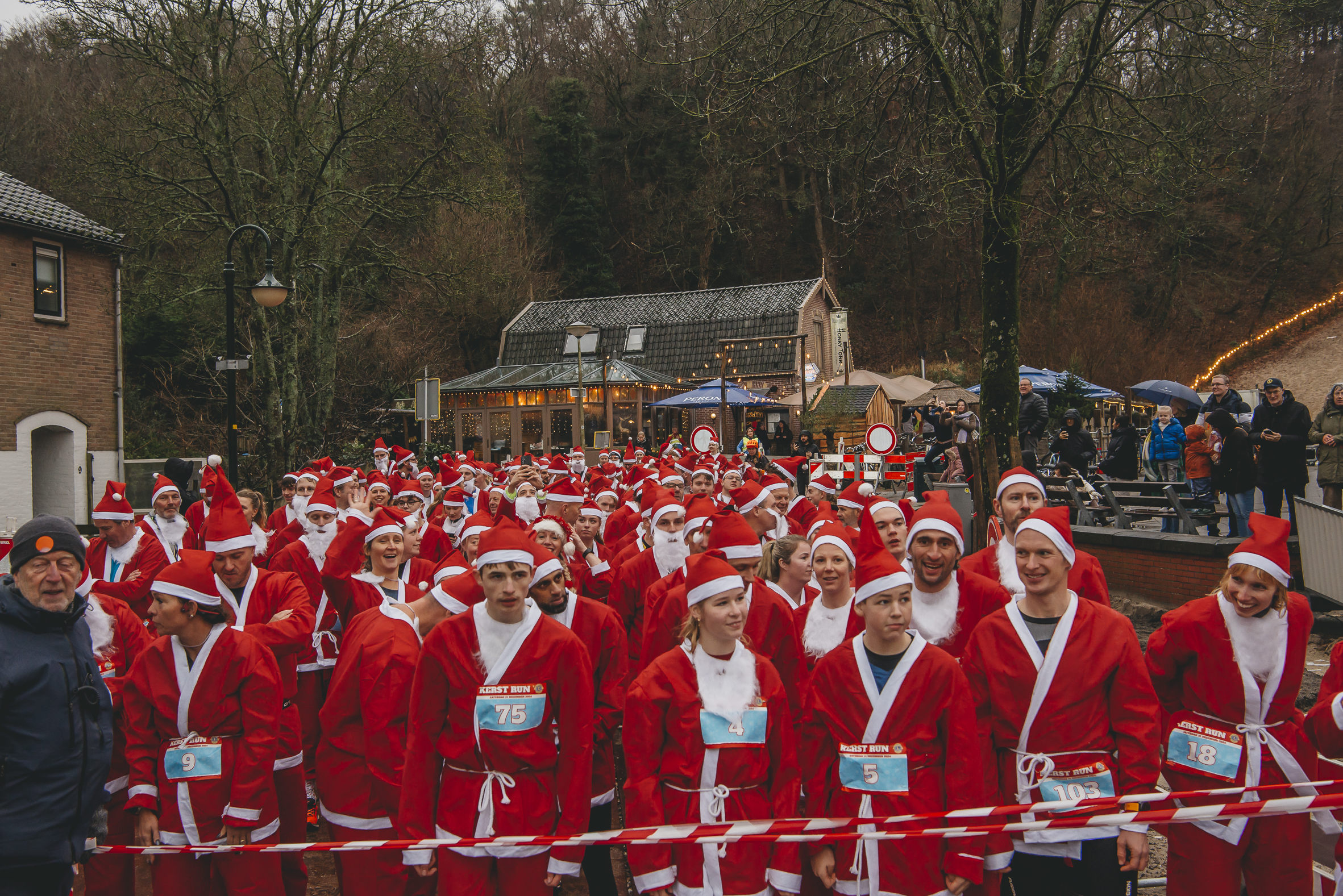 mensen in een kerstmanpak aan de start van een hardloopwedstrijd